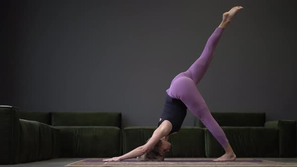 Lonely Woman in Sportswear Doing Side Plank in a Spacious Yoga Studio