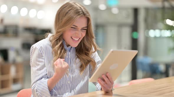 Excited Businesswoman Celebrating Success on Tablet