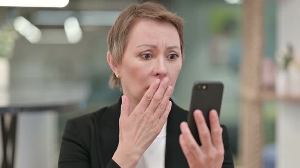 Old Businesswoman Having Loss on Smartphone 