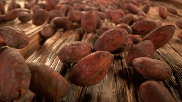 Super Slow Motion Detail Shot of Chocolate Beans Rolling Towards on Wooden Background at 1000Fps