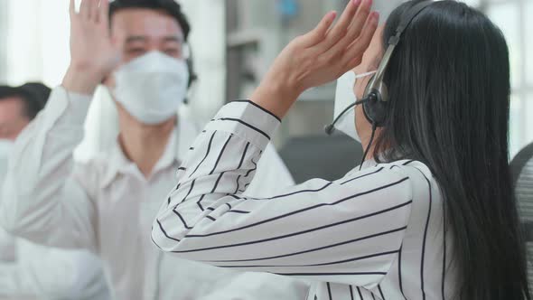 Close Up Of Three Asian Call Centre Agents In Masks Being Happy Due To Success Working