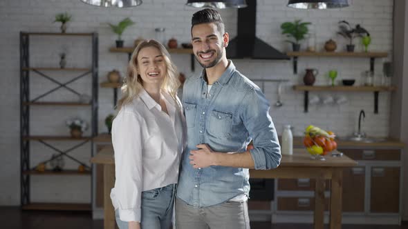 Happy Loving Interracial Couple Posing in Kitchen at Home