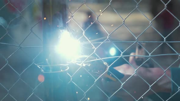 Arc welding close up sparks fence construction