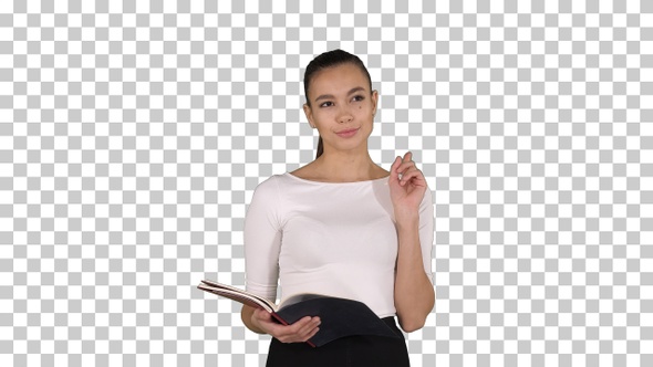 Young business woman walking and reading from notebook