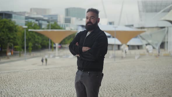 Confident Young Man Standing on Square with Crossed Arms