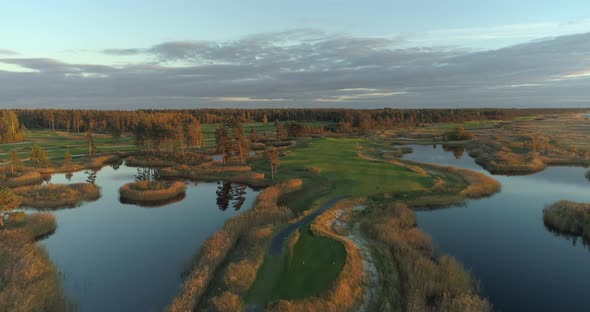 Golf Course Aerial View with Lakes and Green Islands at Sunset