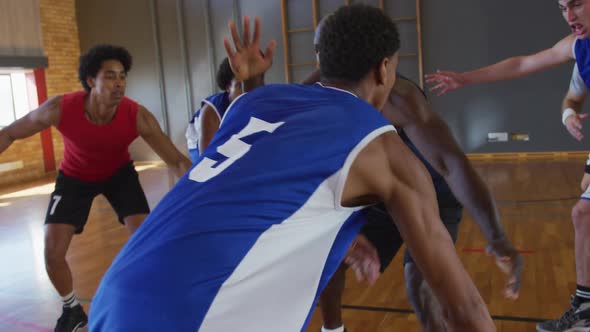 Diverse male basketball team and coach playing match