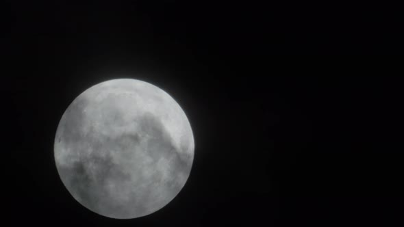 Full Moon Rises Behind the Clouds