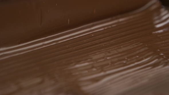 Melted chocolate pouring in a candy factory