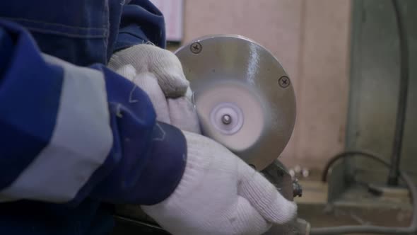 A Worker Burnishes the Finished Silver Spoon with a Machinetool