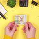 The hands of a young girl are counting many hundred dollar bills on a bright yellow background - VideoHive Item for Sale