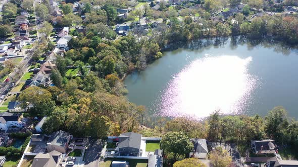 An aerial view of Grant Pond in a Long Island, NY suburb. The camera truck right tilted down over th