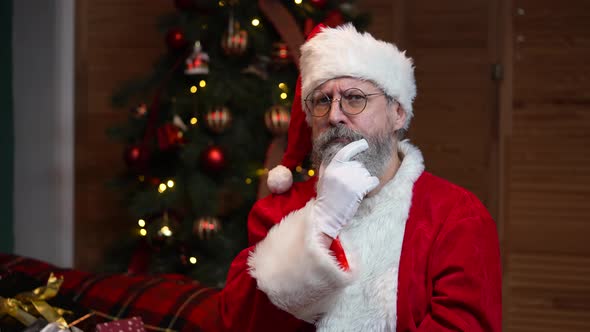 Portrait of Santa Claus Looking at Camera Listens Attentively and Makes a Gesture Ok