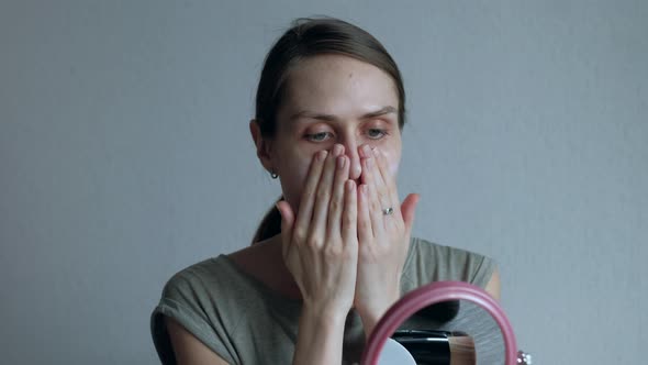 Woman Puts a Cream Foundation on the Face