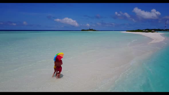 Two people sunbathing on tropical resort beach journey by transparent water and white sandy backgrou