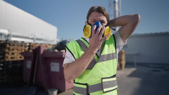 Portrait of Brunette Caucasian Adult Man Putting on Respirator Mask in Slow Motion Looking Around