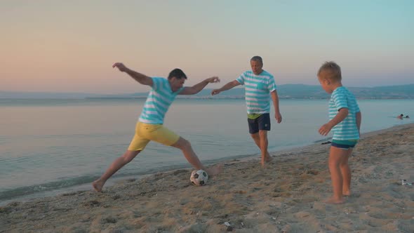 Men and Boy Playing Football on the Beach