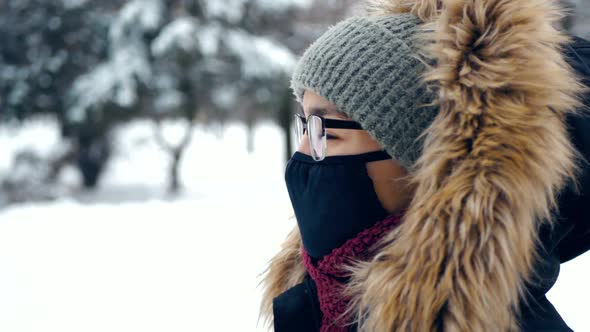 An Attractive Woman in a Green Hat and a Fluffy Hood Observing the Rules of Personal Protection