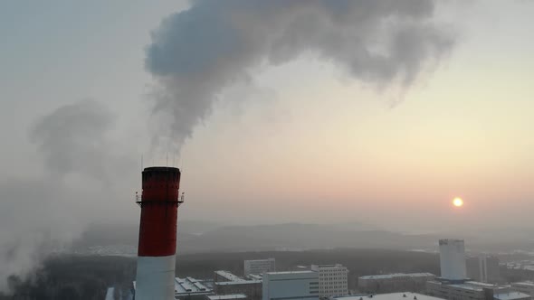 Industrial Zone with a Large Red and White Pipe Thick White Smoke Is Poured From the Factory Pipe in