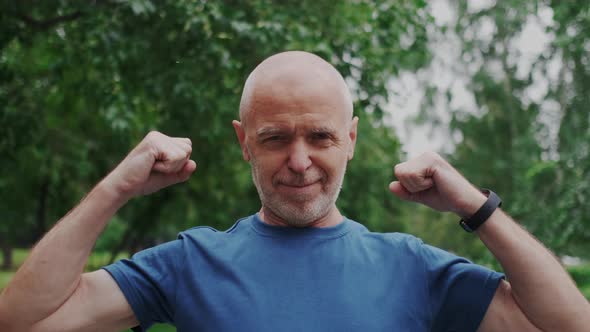 Cool Happy Grandfather or Elderly Man Looking in Camera and Showing Bicep Demonstrate Strongness