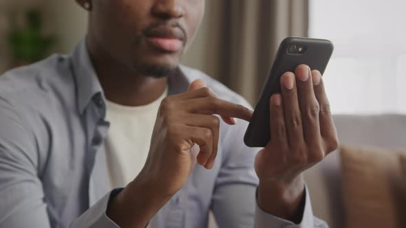 Close Up of an Unrecognisable African American Young Adult Man Swiping on a Black Smart Phone and