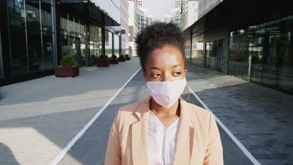 Black Business Lady in Face Mask Posing for Camera on Street