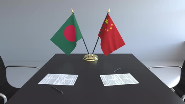 Flags of Bangladesh and China and Papers on the Table alt