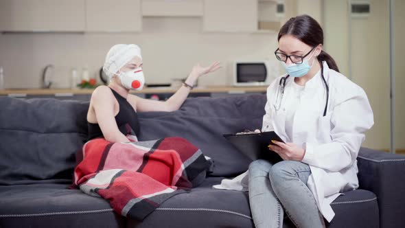 Concentrated Female Doctor in Eyeglasses and Covid Face Mask Taking Medical History of Patient 