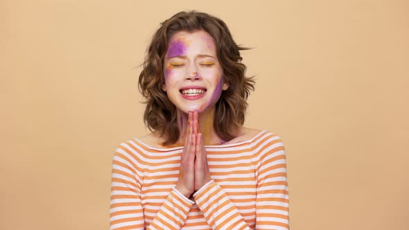 Portrait of Dreaming Artistic Woman Wearing Multicolored Makeup Stains on Face and Praying God