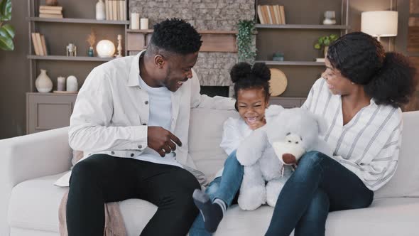 Biracial Family Sitting on Couch in Living Room Spending Weekend Together