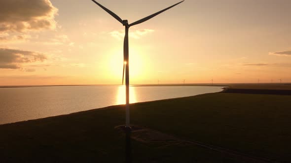 Aerial View of Wind Turbines and Agriculture Field Near the Sea at Sunset