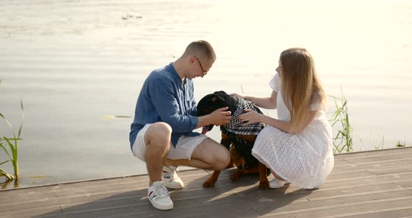 Loving Young Couple with a Dog By Lake