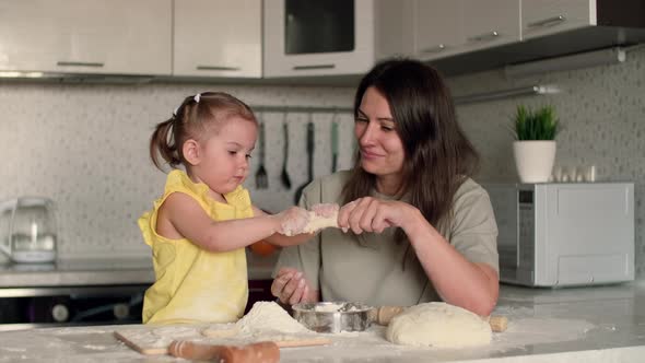 Cheerful Mother and Daughter are Fooling Around While Cooking Pastries From Dough