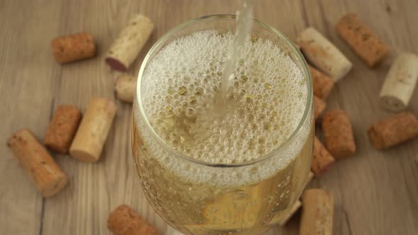 Wine is poured into a glass on the background of wine corks.	