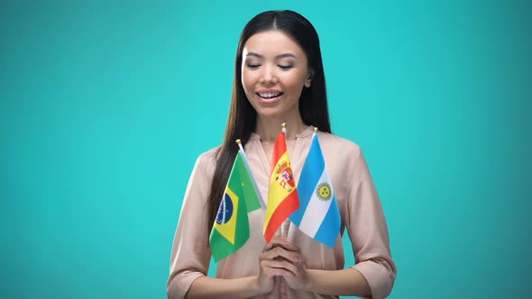 Curious Woman Holding Brazil, Spain and Argentina Flags, Learning Language