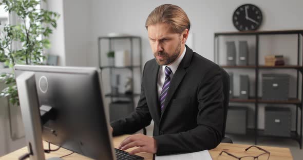 Man Sitting at Office and Working on Computer