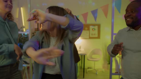 Slow Motion Portrait of Joyful Business Lady Dancing in Decorated Office with Coworkers