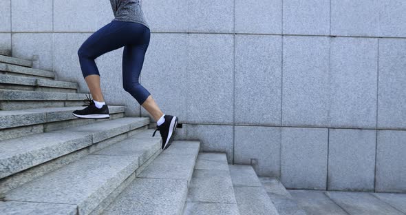 Fitness sports woman running up stairs in city