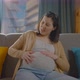 Pregnant Woman Sitting on the Couch Having Labor Contractions Pain - VideoHive Item for Sale