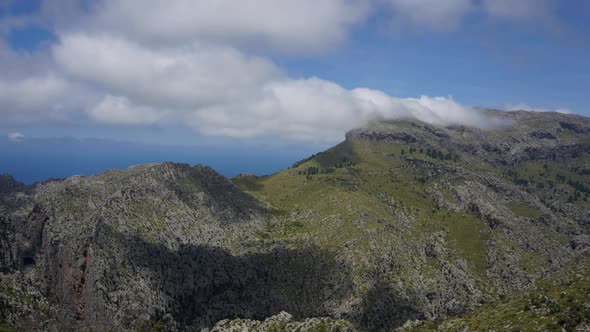 TIME LAPSE: Clouds passing by over mountains on a sunny island.