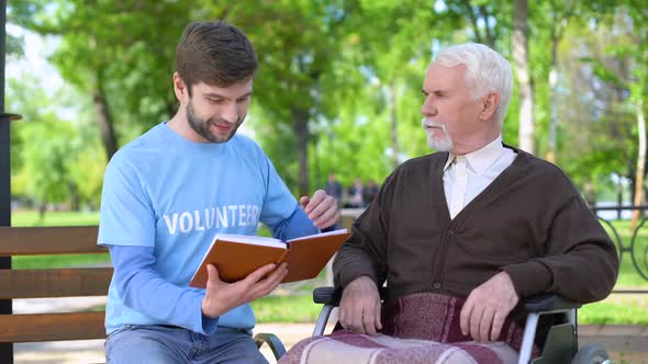 Social Worker Reading Book for Disabled Pensioner, Leisure in Park, Volunteering