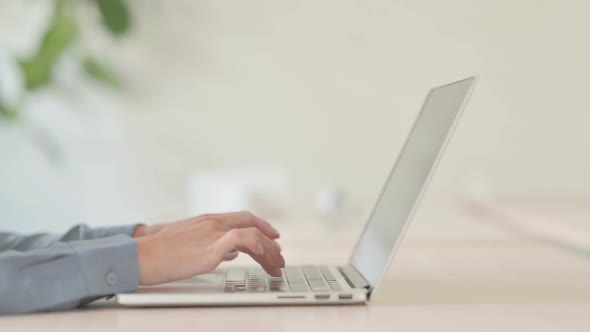 Side View of Woman Typing on Laptop Keyboard