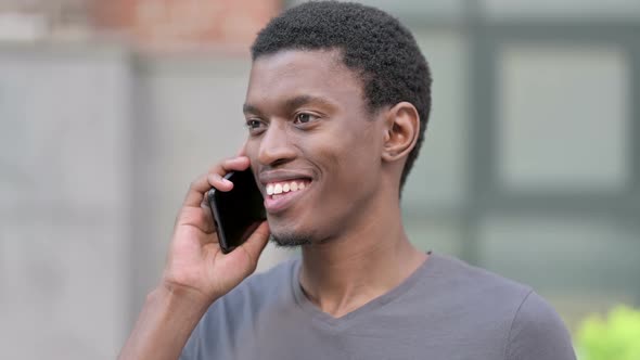 Portrait of Cheerful Young African Man Talking on Smartphone