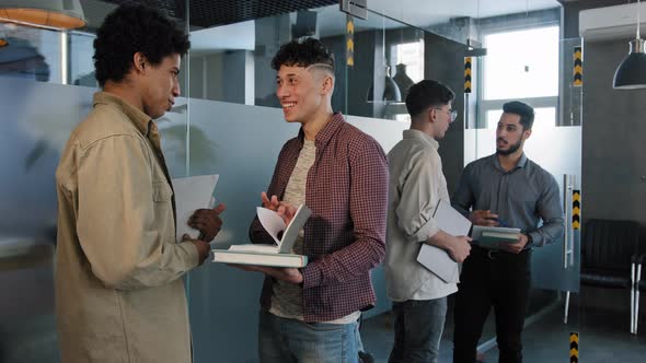 Young Male Students Stand Indoors Communicate Preparing Exam Caucasian Woman Student Joyfully Runs