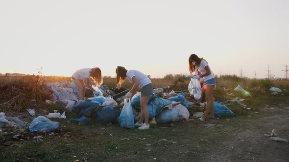 Group of Eco Volunteers Cleaning Up Area of Dump Near the Field During Sunset Gimbal Shot Slow