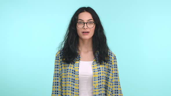 Attractive Female with Dark Curly Hair and Glasses Looking at Camera Starts to Understand and Snap