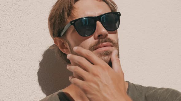 Portrait of young handsome man posing outdoors near wall