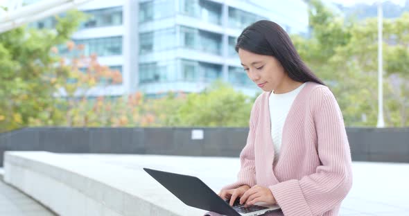 Woman working on laptop computer at outdoor