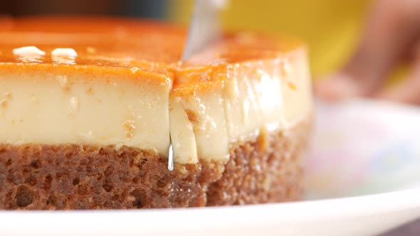 Cutting Caramel Custard Pudding on a Plate on Table