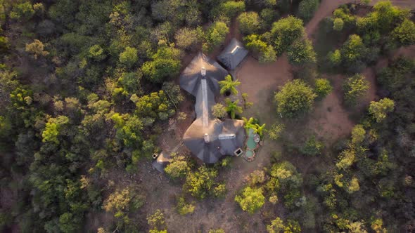 Aerial top down view of beautiful cottages built in middle if dense greenery in South Africa.